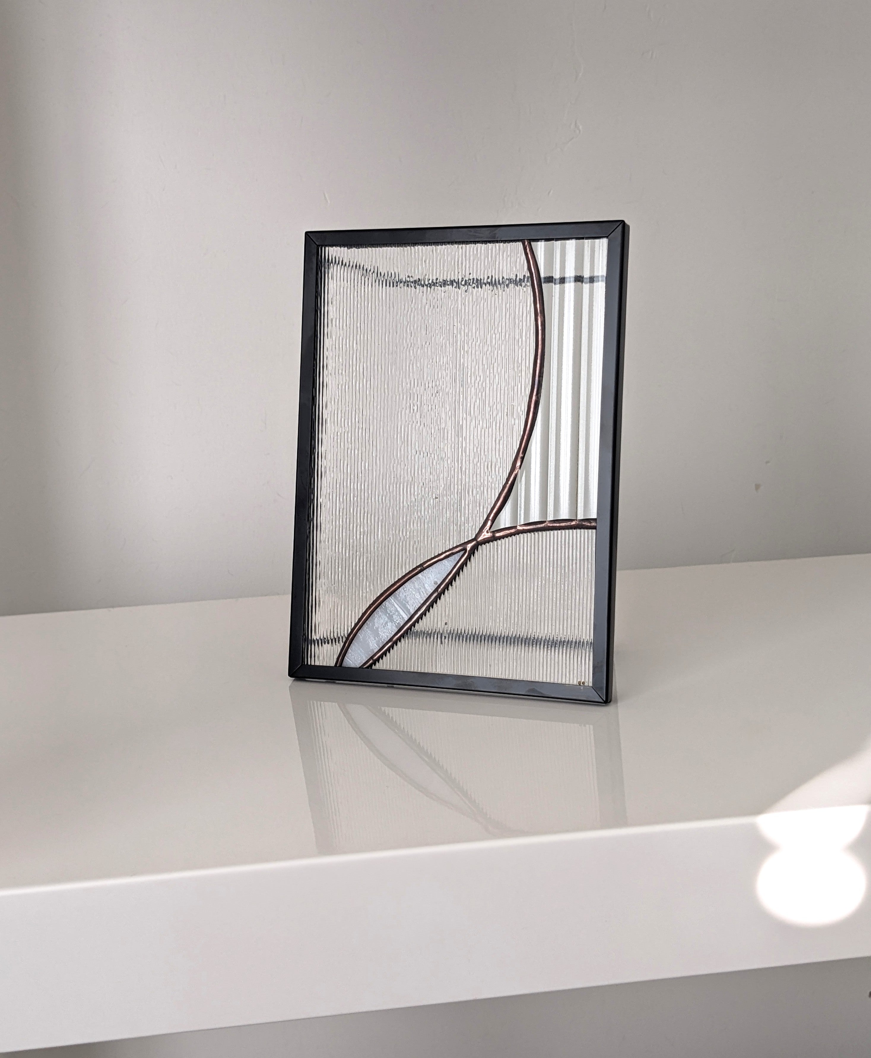 Decorative glass art with abstract design on a white surface