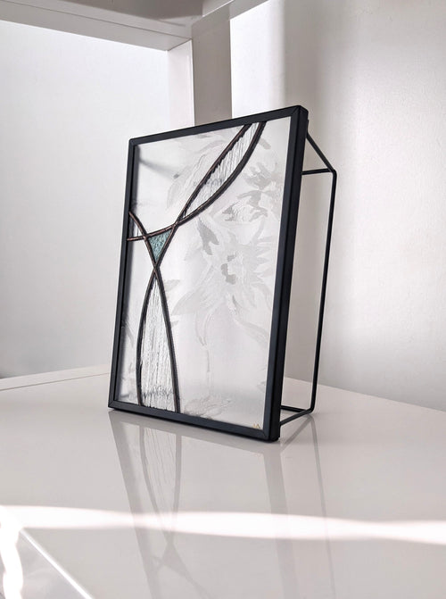 Modern black-framed glass panel on a white surface with a white background